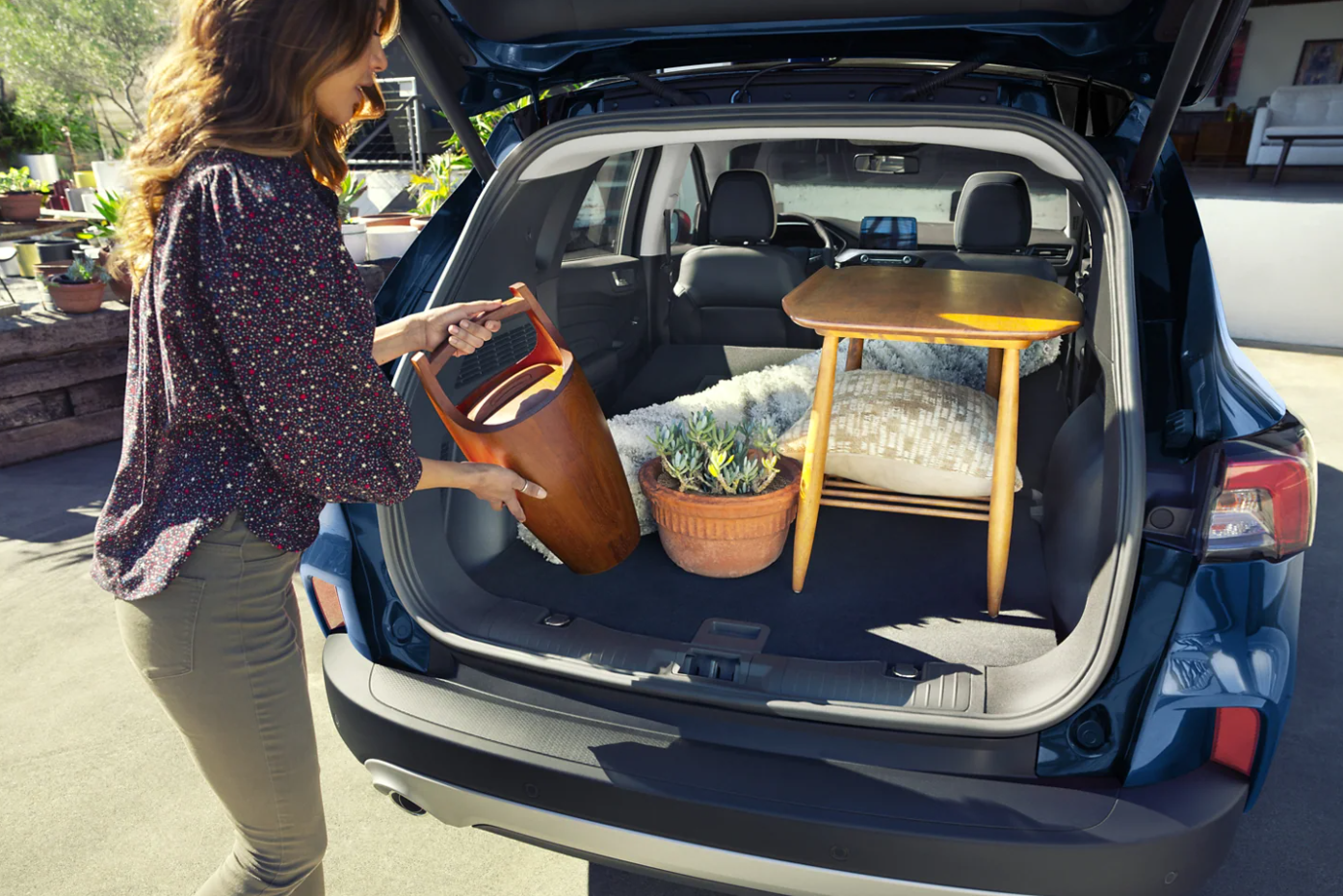 A woman loads the cargo space behind the second-row seating in her 2022 Ford Escape