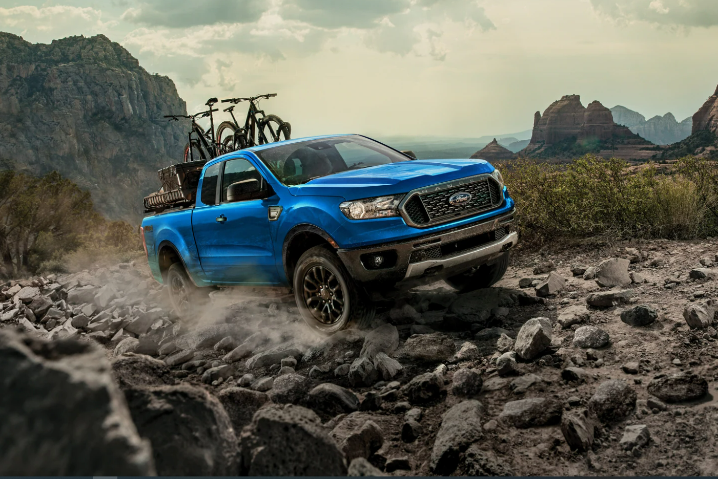 A view of the front of a blue 2023 Ford Ranger as it climbs a rocky hill